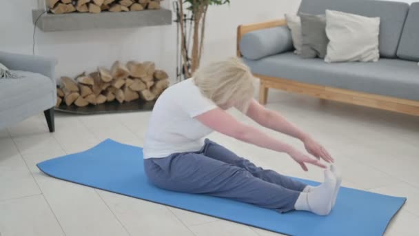 Senior Old Woman gör Stretches på Yogamattan hemma — Stockvideo