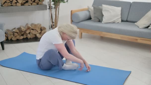 Vieille femme âgée faisant des étirements sur tapis de yoga à la maison — Video