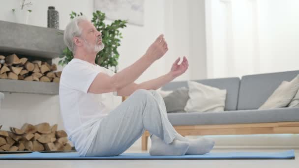 Senior Old Man mediterar på Yogamattan hemma — Stockvideo