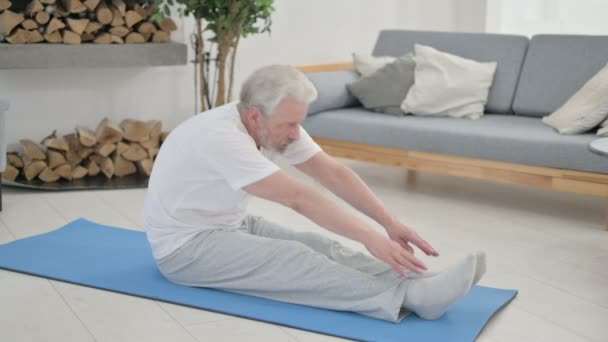 Vieil homme âgé faisant des étirements sur tapis de yoga à la maison — Video