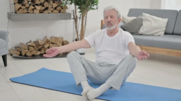 Senior Old Man gör Stretches på Yogamattan hemma — Stockvideo