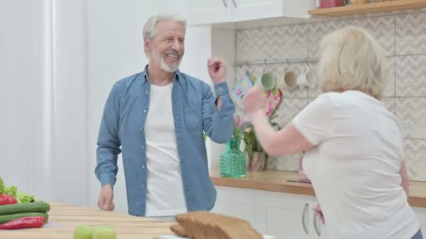 Здоровые пожилые пары танцуют на кухне — стоковое видео