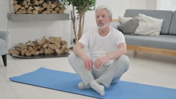 Senior Old Man mediterar på Yogamattan hemma — Stockvideo