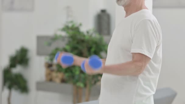 Крупный план пожилого человека, упражняющегося с гантелями — стоковое видео