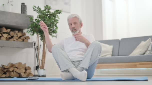 Anciano mayor escuchando música en auriculares y meditando — Vídeo de stock