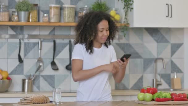 Afrykańska kobieta robi zdjęcia owoców na smartfonie w kuchni — Wideo stockowe
