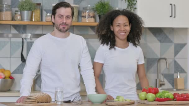 Blandad ras par ler mot kameran i köket — Stockvideo