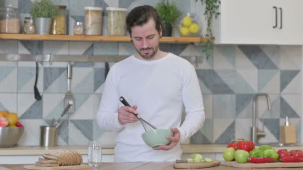 Gezonde jonge man koken in de keuken — Stockvideo