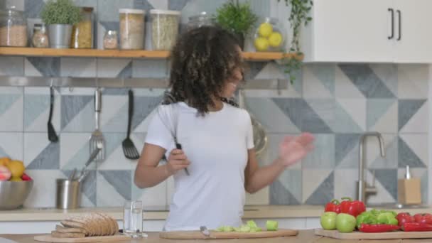 Joven mujer africana bailando mientras cocina en la cocina — Vídeos de Stock