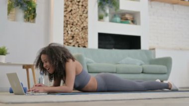 Genç Afrikalı Kadın Yoga Mat 'teyken laptopta konuşuyor. 