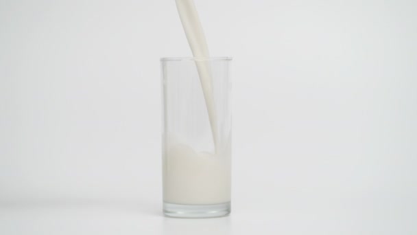 Mouvement lent de verser le lait dans le verre à 1000fps, fond bleu — Video