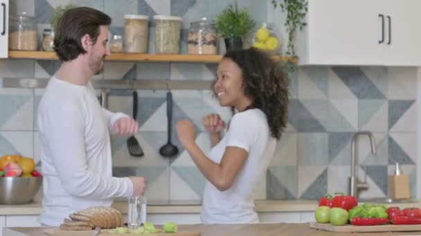 Fröhliches gemischtes Paar tanzt in Küche — Stockvideo