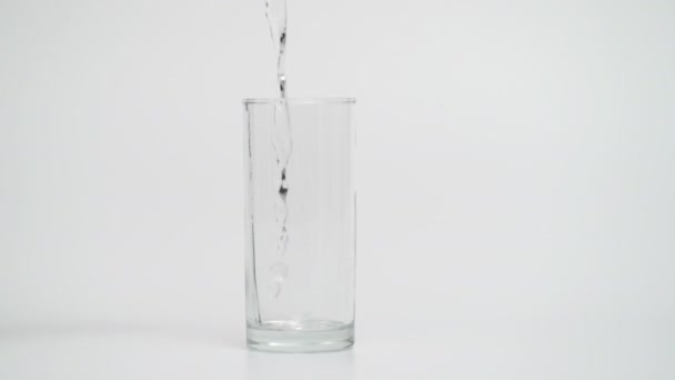 1000 fps Tiro de agua de verter en vidrio, fondo blanco — Vídeo de stock