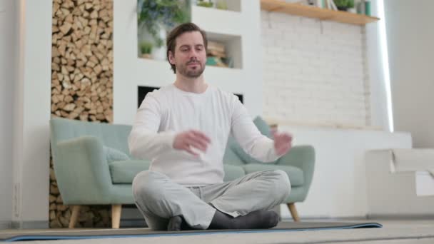 Ragazzo pacifico che medita sul tappetino di yoga a casa — Video Stock