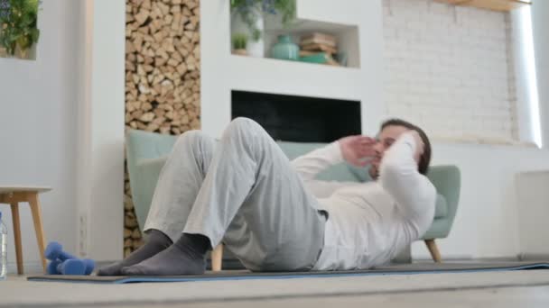 Jovem fazendo treino no tapete de ioga em casa — Vídeo de Stock