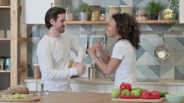 Feliz mixta carrera pareja bailando en cocina — Vídeo de stock