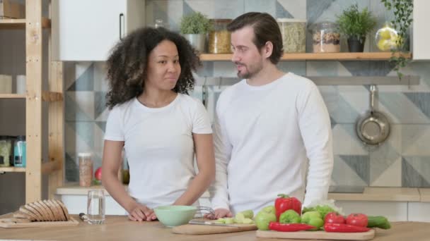Blandad ras par diskuterar i köket — Stockvideo