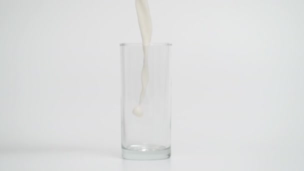 Super cámara lenta de gotas de leche cayendo en vidrio transparente — Vídeos de Stock