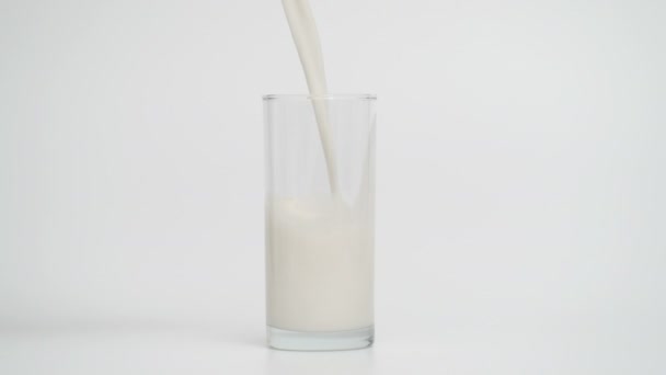 Movimento lento del latte versato in vetro a 1000fps, sfondo blu — Video Stock