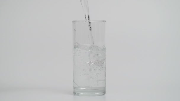 1000 fps de inyección de agua de verter en vidrio transparente, fondo blanco — Vídeo de stock