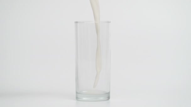 Mouvement super lent de verser du lait dans du verre transparent — Video