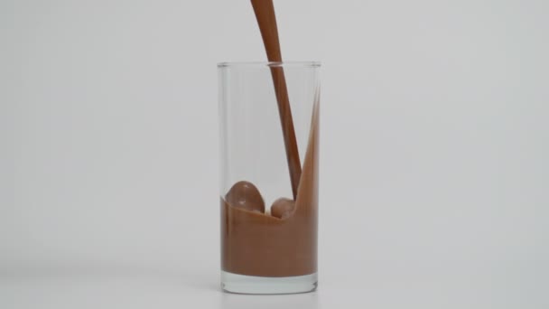 Super lento movimento di riempimento vetro trasparente con latte al cioccolato — Video Stock