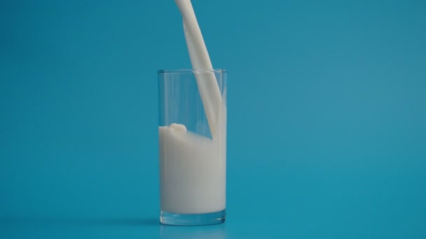 Повільний рух розливу молока в склянку зі швидкістю 1000 к/с — стокове відео
