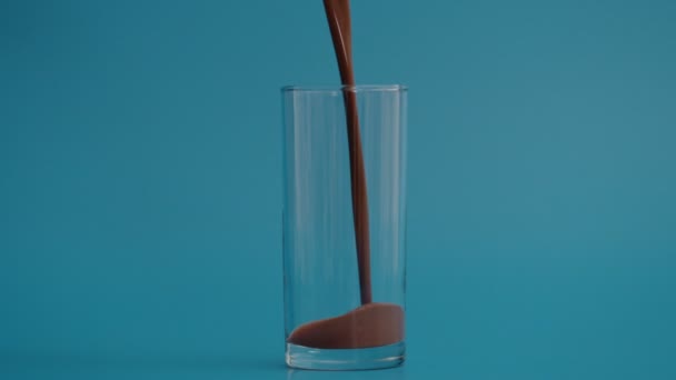 Superlangzame beweging van het gieten van chocolade in doorzichtig glas bij 1000 fps — Stockvideo