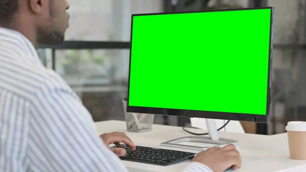 Afrikaner benutzt Desktop mit grünem Chroma-Schlüsselbildschirm — Stockfoto