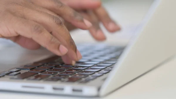 Mãos perto do homem africano usando laptop — Fotografia de Stock