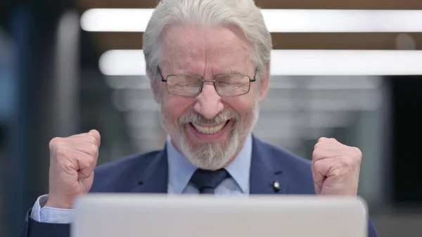 Nahaufnahme eines alten Geschäftsmannes, der seinen Erfolg am Laptop feiert — Stockfoto