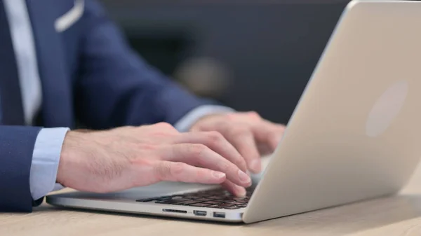 Ręce zbliżenie w górę w średnim wieku biznesmen wpisując na laptopie — Zdjęcie stockowe