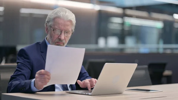 Antiguo Empresario Leyendo Documentos, Trabajando en Ordenador Portátil —  Fotos de Stock