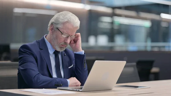 Vieux homme d'affaires avec ordinateur portable faisant la sieste au travail — Photo