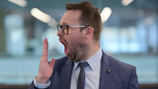 Porträtt av sömnig medelålders affärsman Yawning — Stockfoto