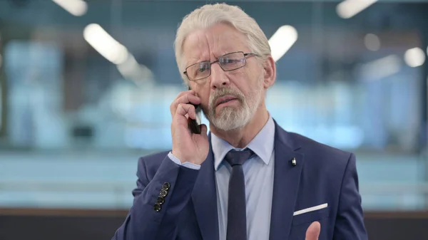 Portrait of Old Businessman Talking on Phone