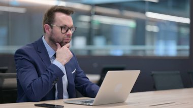 Orta Çağ İşadamı Laptop kullanarak Düşünüyor