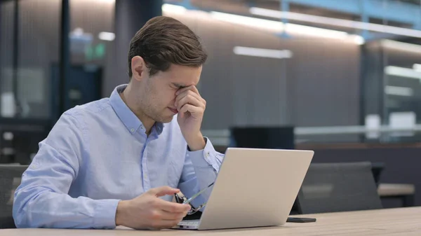 Jongeman met Laptop die hoofdpijn heeft — Stockfoto