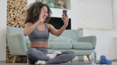 Afrikalı Kadın Fitness Mat 'ten Smartphone aracılığıyla çevrimiçi Video Sohbeti