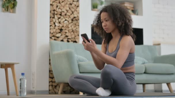 Fitness 'ten sonra akıllı telefon kullanan genç Afrikalı kadın — Stok video