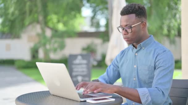 Afrikansk mann som arbeider på Laptop i utendørs kafe – stockvideo