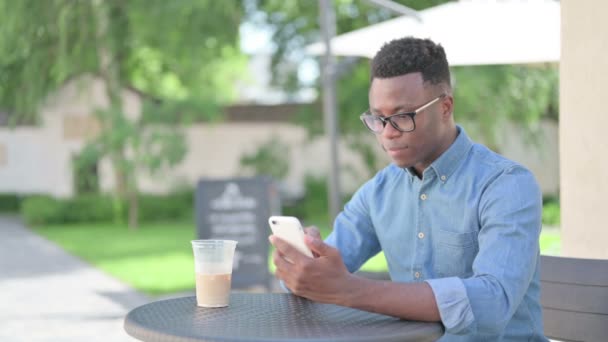 Hombre africano usando Smartphone en Café — Vídeos de Stock