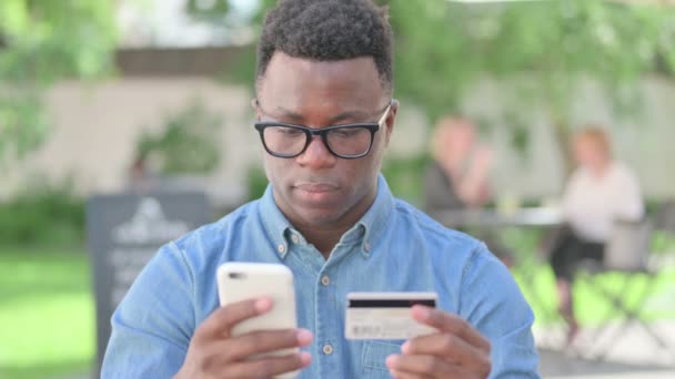 Retrato del hombre africano haciendo pago en línea en Smartphone — Vídeos de Stock