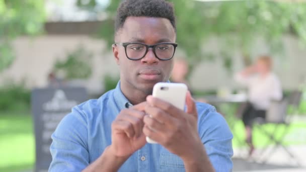Портрет африканца, говорящего на смартфоне — стоковое видео