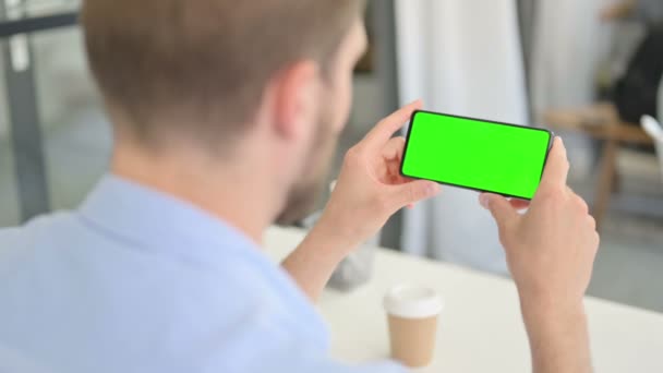 Homem criativo jovem olhando para Smartphone com tela Chroma — Vídeo de Stock