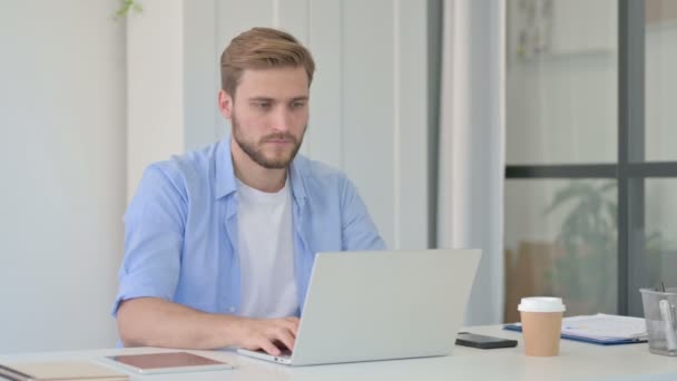 Polegares para baixo por jovem criativo homem com laptop no escritório — Vídeo de Stock
