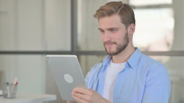 Retrato de un joven creativo celebrando el éxito en la tableta — Vídeo de stock