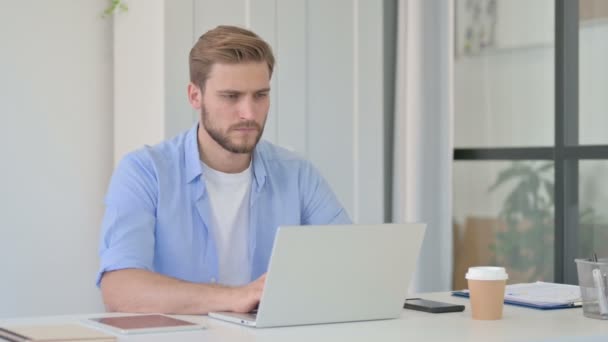 Joven creativo con dolor de cabeza en el trabajo — Vídeos de Stock