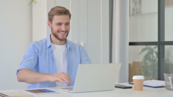 Joven hombre creativo hablando en videollamada en el ordenador portátil — Vídeos de Stock