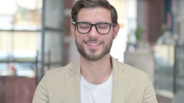 Kafasını sallayan genç adamın portresi Evet işareti 